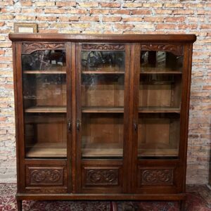 Biblioteca tres puertas con estantes regulables y tableros tallados